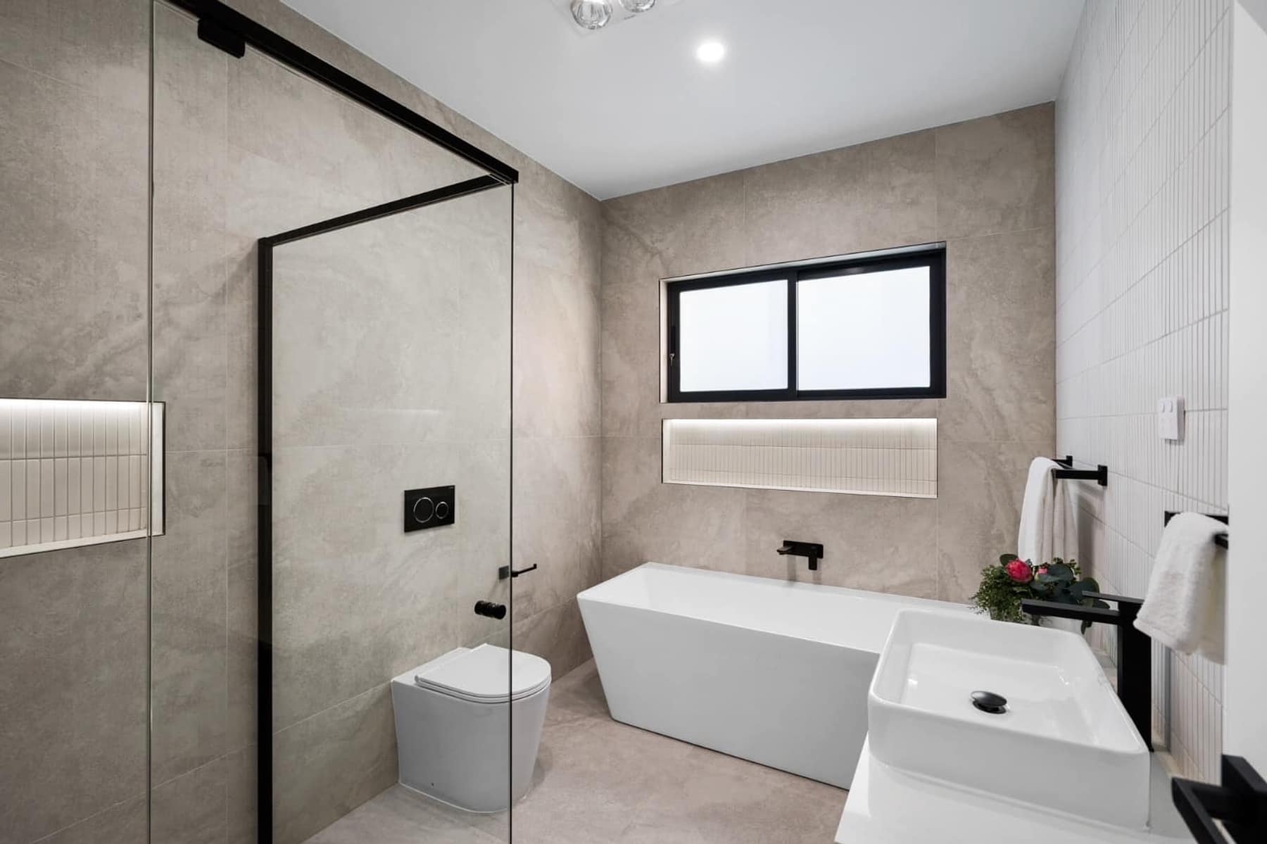 Main bathroom with freestanding bath, frameless shower and matte-black tapware