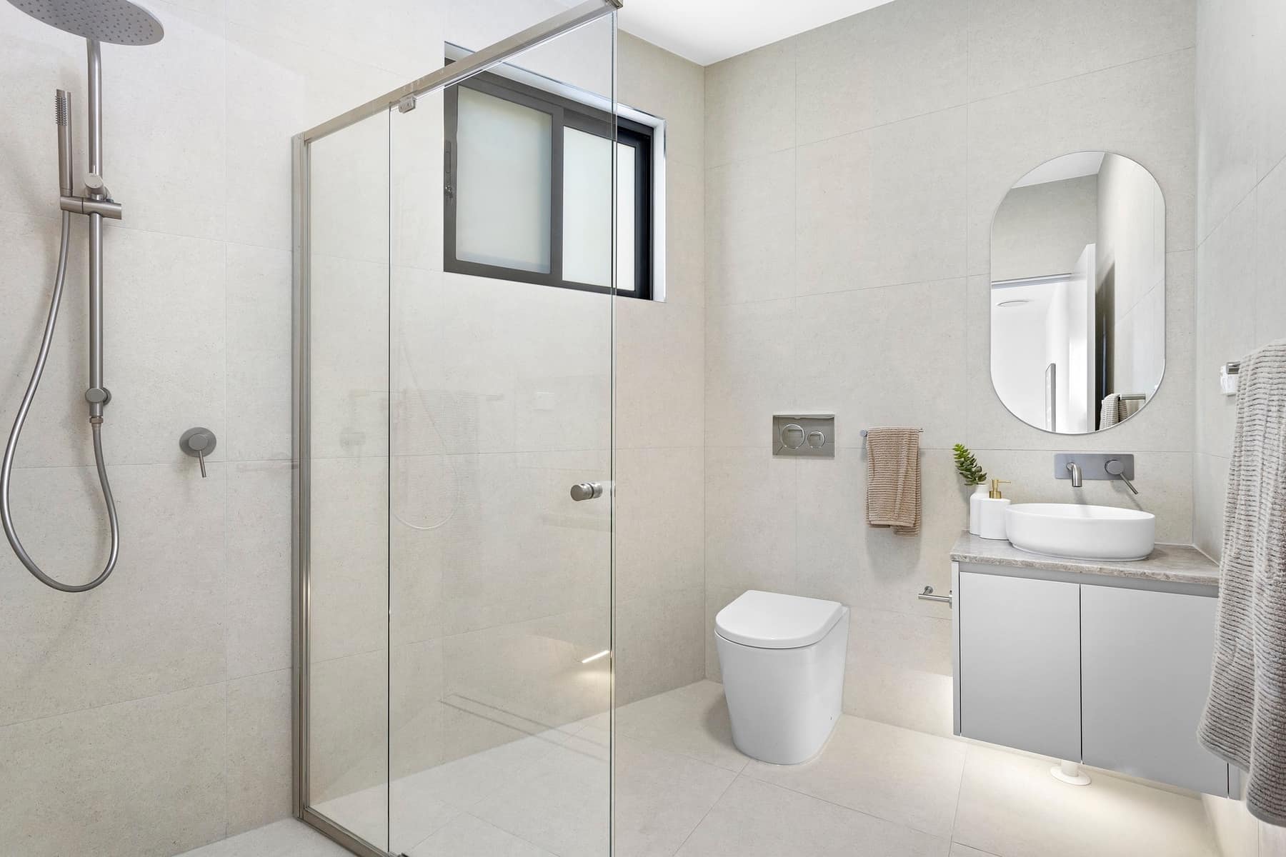 Bathroom with frameless shower, wall-hung vanity and vessel basin