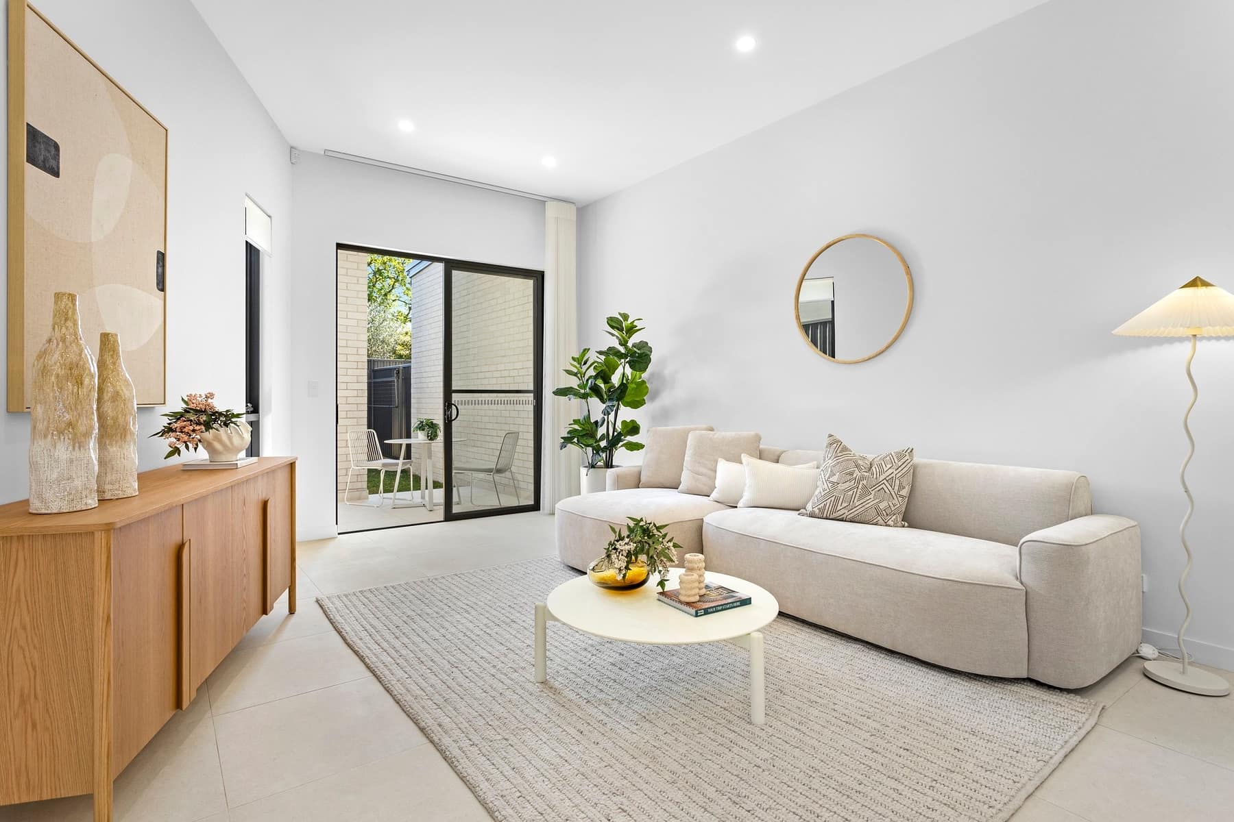 Open-plan living room with tiled floors and glazing to the courtyard