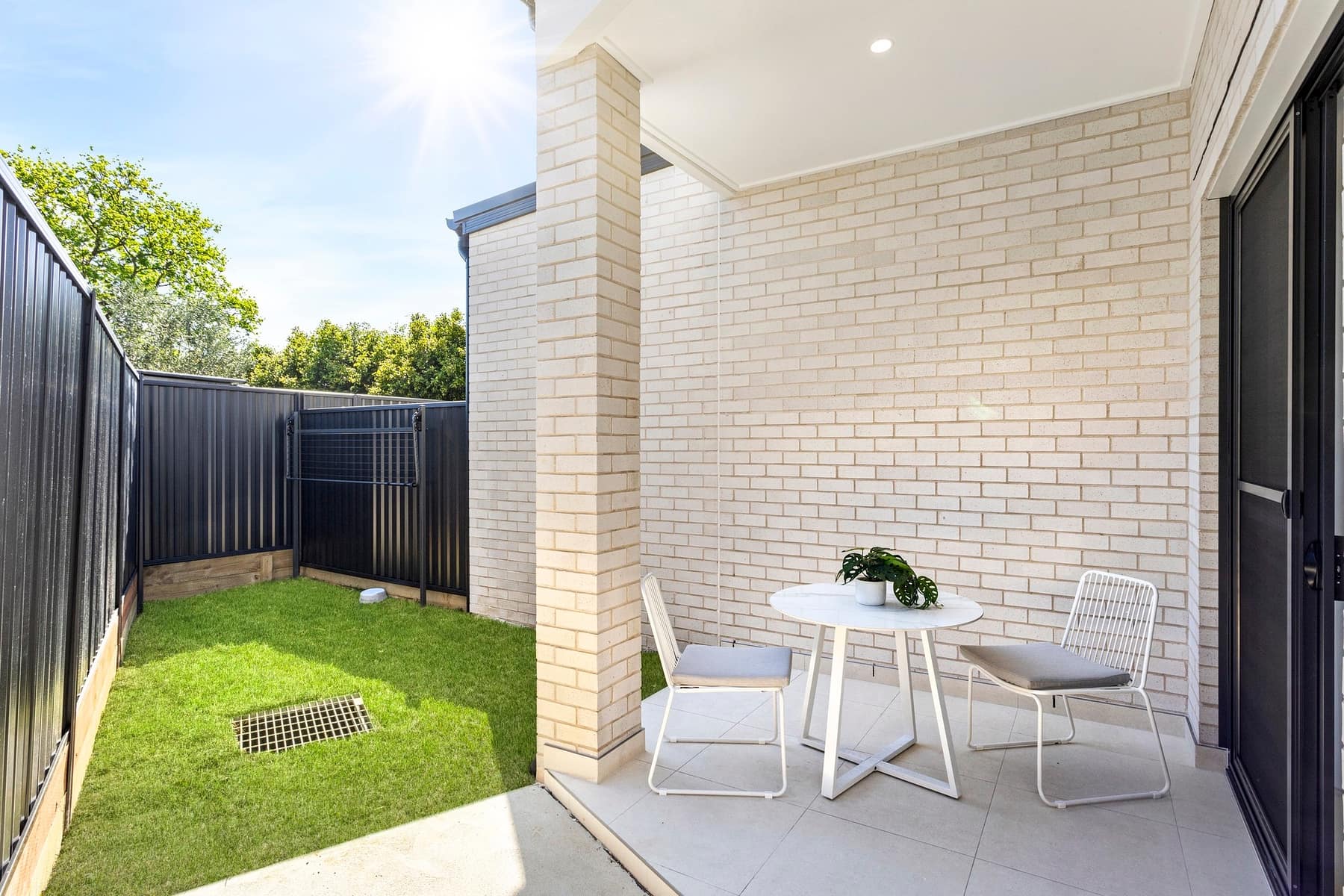 Covered alfresco patio with outdoor dining setting at the Stockton Avenue townhouses